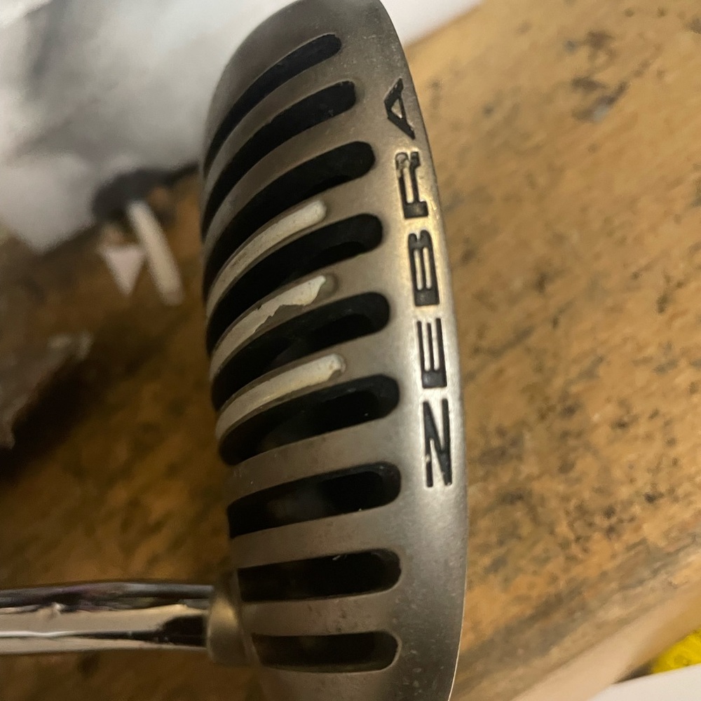 Zebra roll face golf putter in right hand